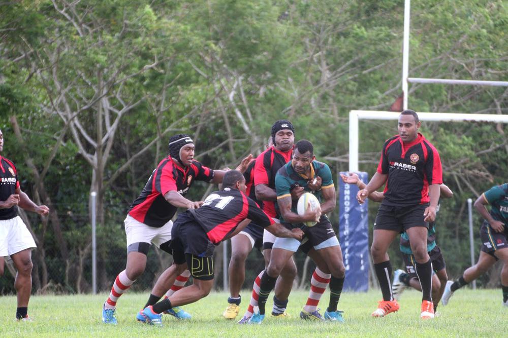 Playing for your job. A player from the Lomaiviti team carries the ball during a preseason match against well-fed members of the Fire Department rugby team (Suva, Fiji, March 2016)