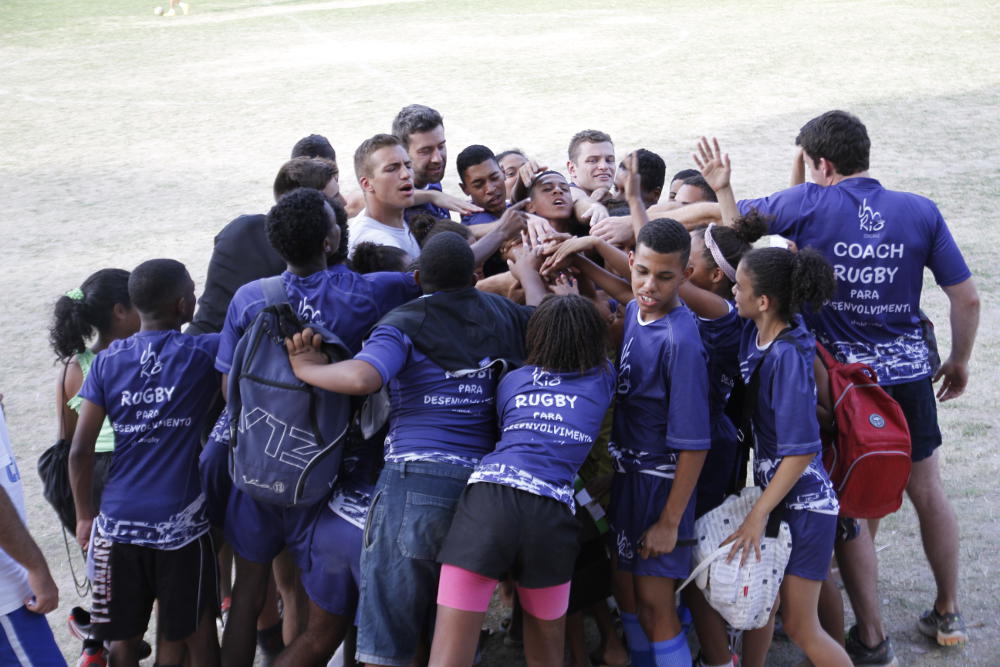 Volunteers and participants form a huddle to mark the end of a training session, Morro do Castro, 2015